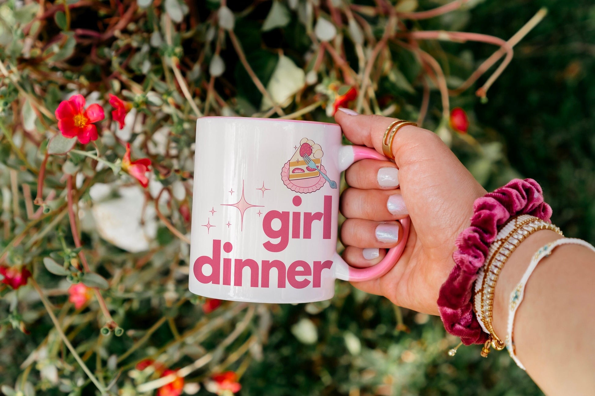 A White and Pink mug that reads &quot;Girl Dinner&quot;. Design features Pink lowercase fonts and a slice of Kawaii strawberry cake.