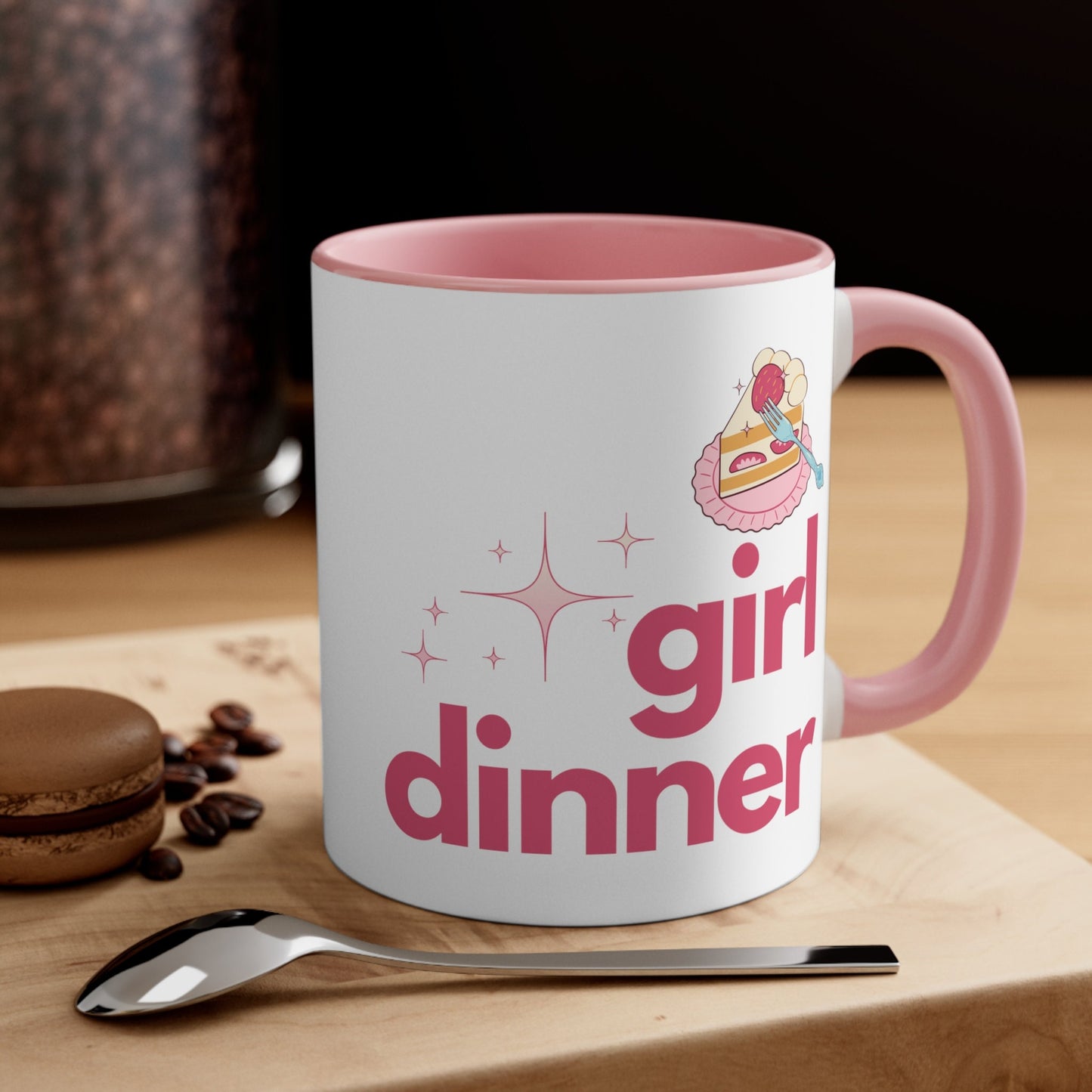 A White and Pink mug that reads &quot;Girl Dinner&quot;. Design features Pink lowercase fonts and a slice of Kawaii strawberry cake.