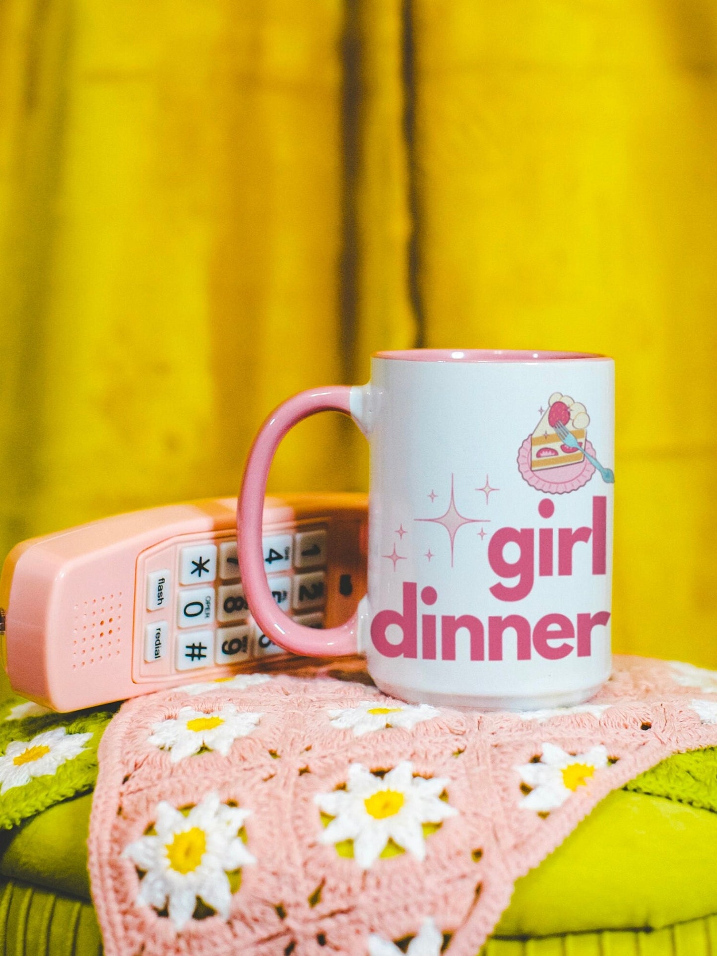 A White and Pink mug that reads &quot;Girl Dinner&quot;. Design features Pink lowercase fonts and a slice of Kawaii strawberry cake.